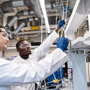 University of Virginia assistant professor of chemical engineering Jason Bates (left) and Ph.D. student Isaac Boateng discuss the configuration of gases interfaced with an electrochemical reactor system.